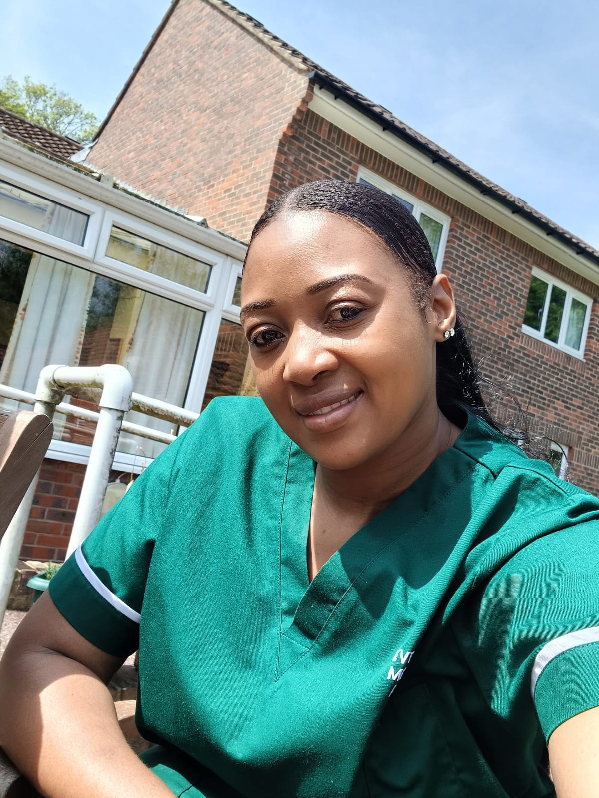 An Evergood Medicals carer on a home visit in bottle green uniform