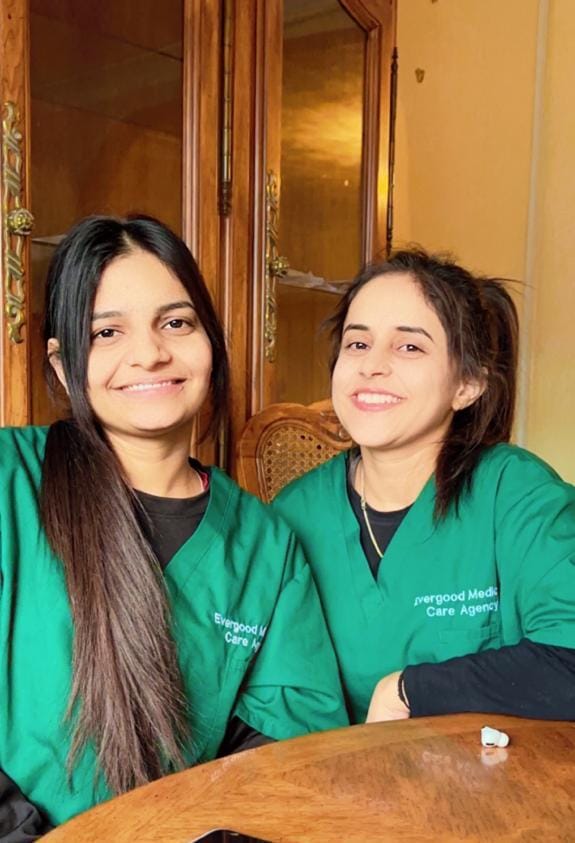 Two Evergood Medicals carers in bottle green uniform, care jobs with a supportive employer in Crawley
